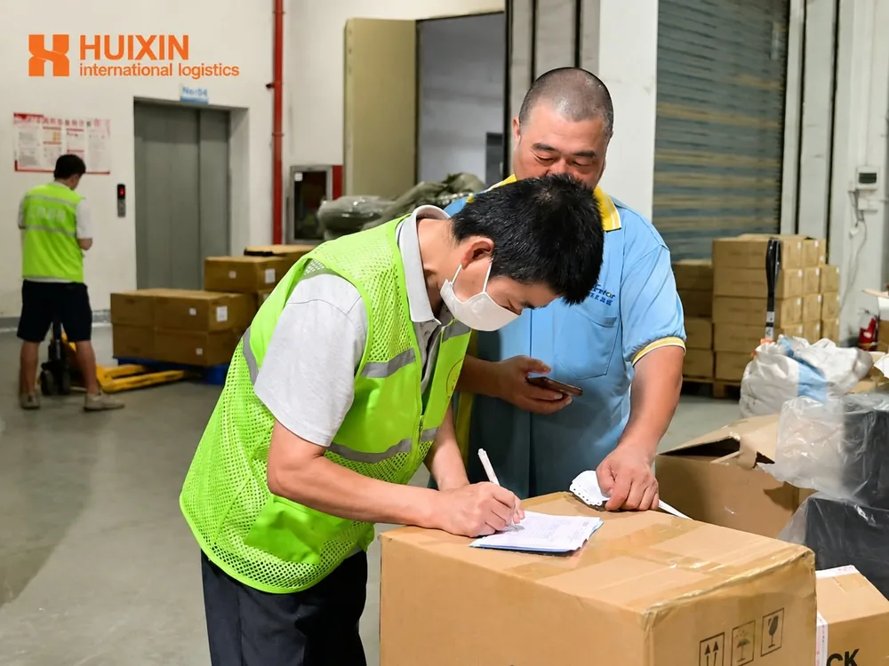 HUIXIN 3PL staff checking apparel cartons during warehouse receiving in China