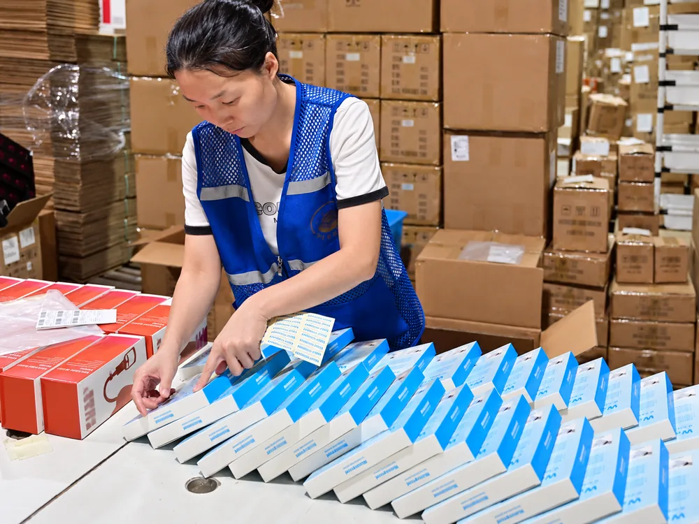 Warehouse worker labeling retail boxes before shipment at a HUIXIN 3PL China warehouse